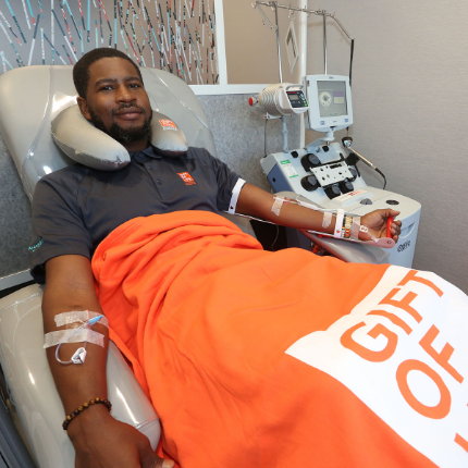 A man smiles the camera as he donates to save a life